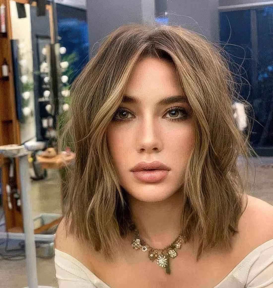 Long layered bob with blonde highlights and messy waves.
