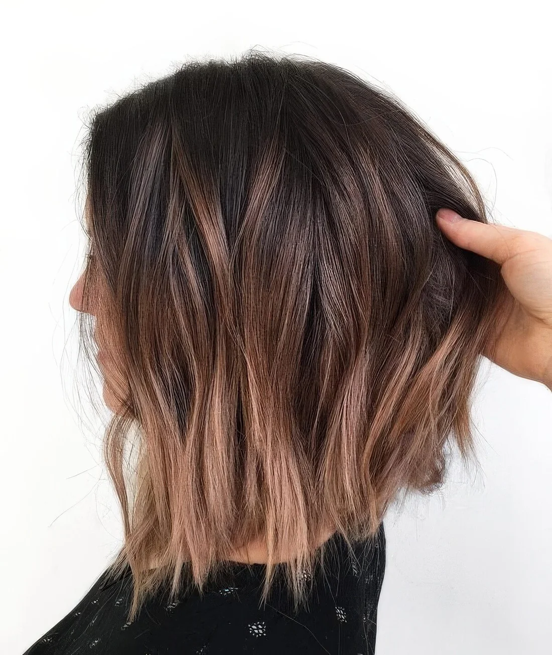 Dark brunette long bob with caramel and mahogany highlights and messy waves.