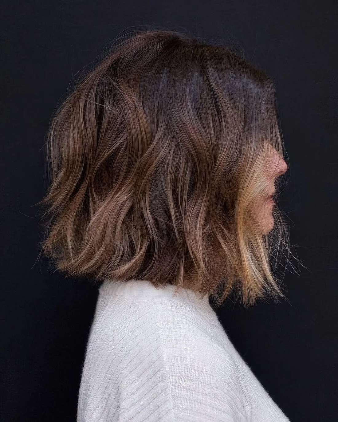 Dark brunette long bob with caramel highlights and a blonde money piece.