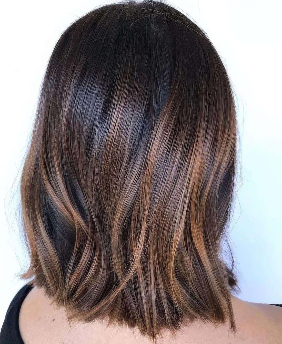 Dark brunette, almost black long bob, with caramel balayage and a bit of texture.
