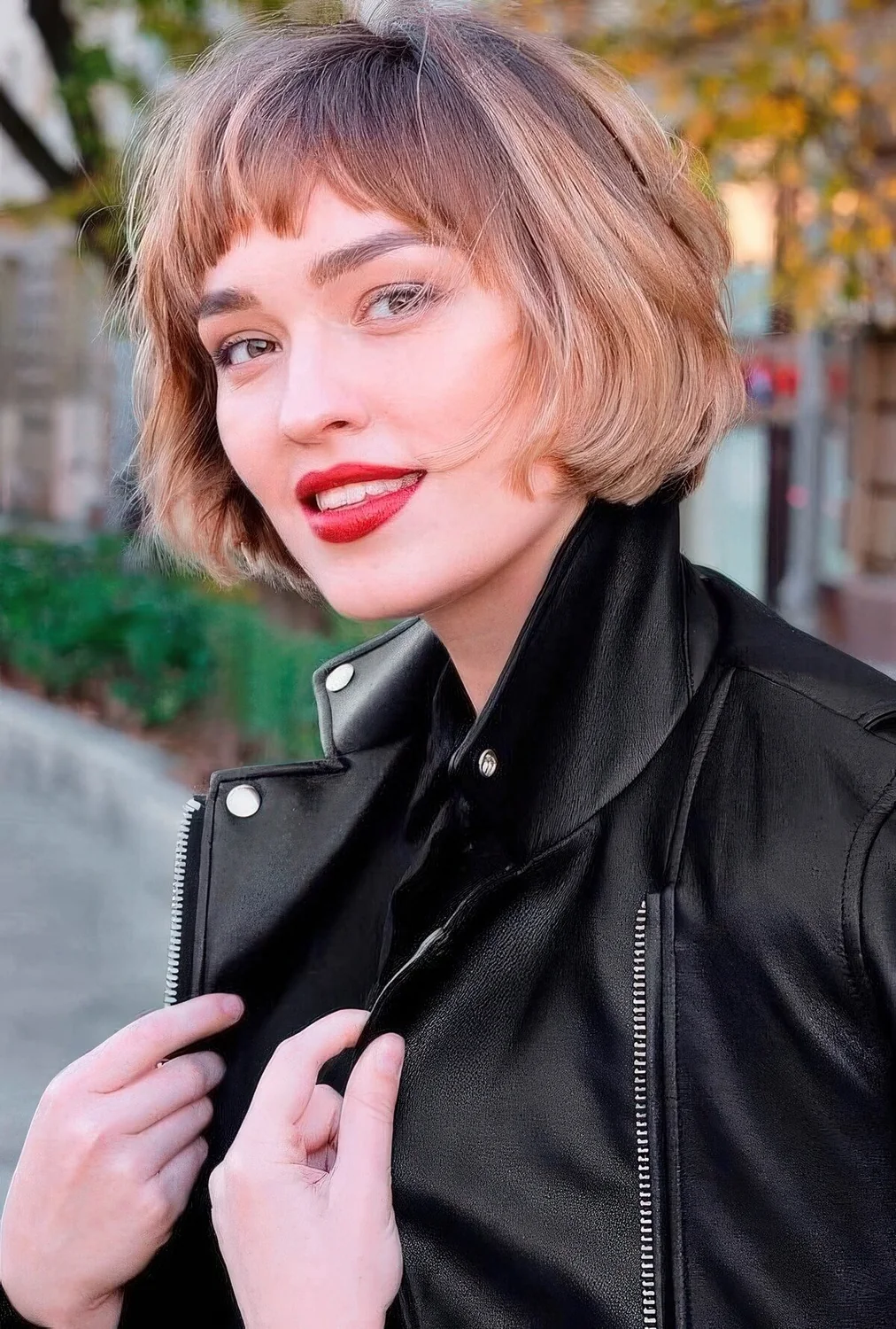 Jaw-length brunette bob with blonde balayage and waves plus bangs.