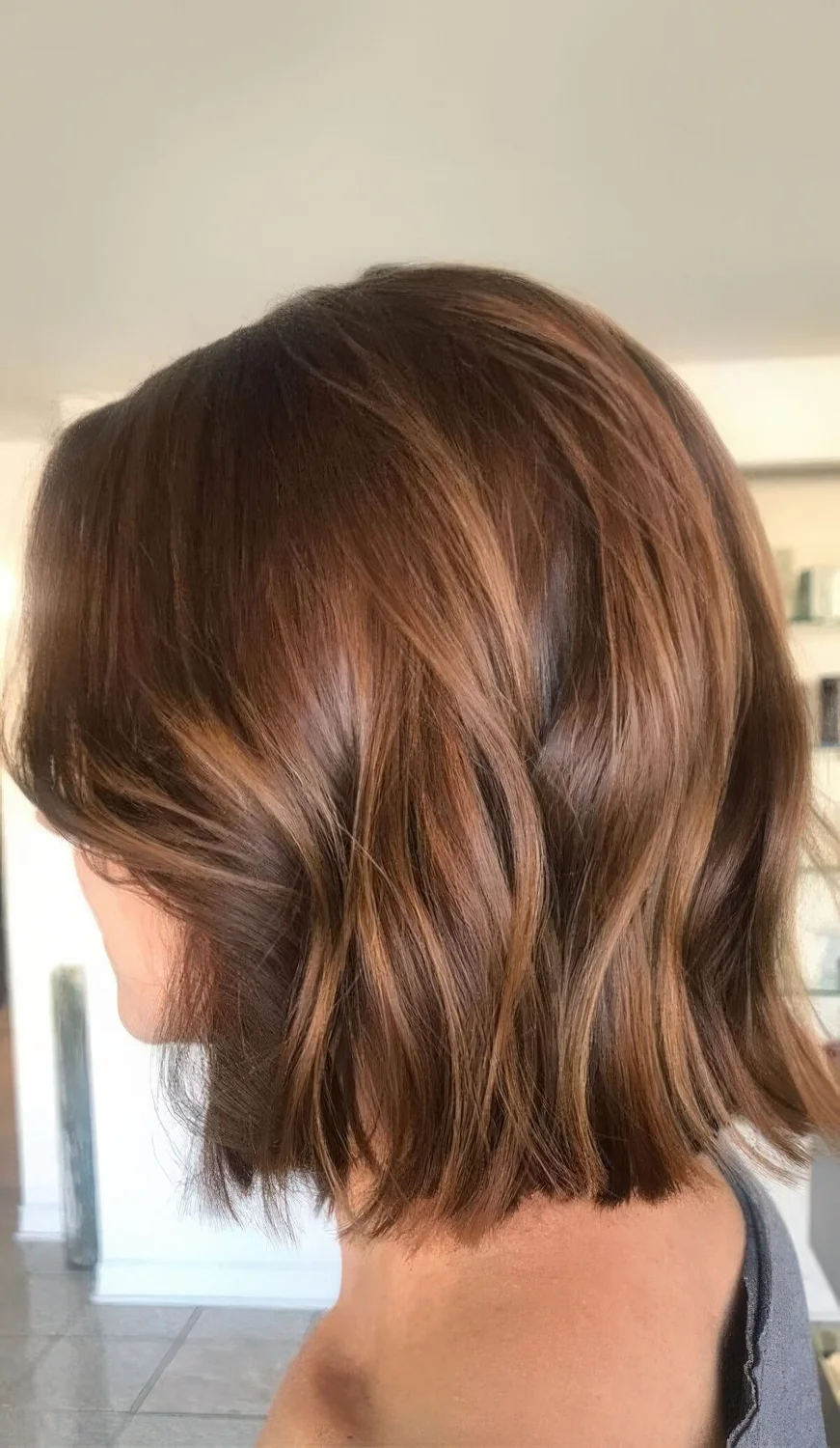 Long brown bob with caramel balayage and waves.