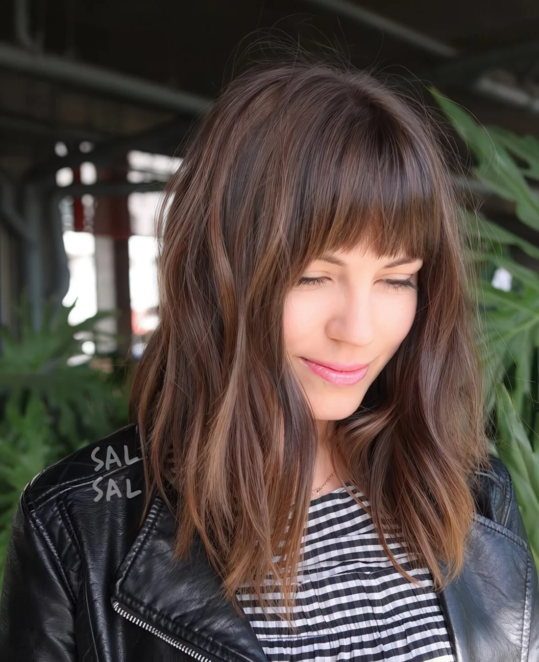 Layered brunette A line lob with fringe bangs and highlights.