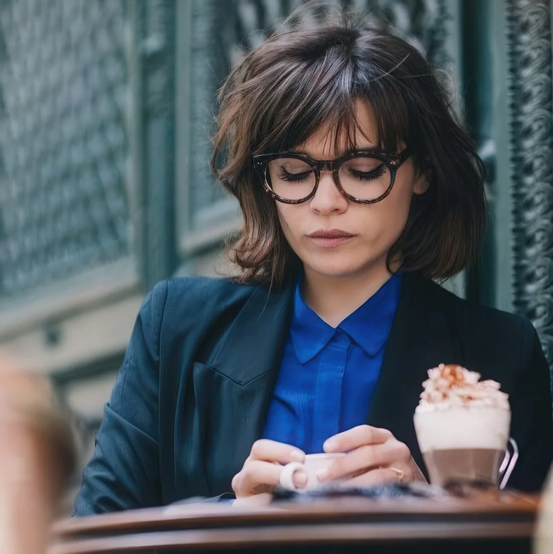 French chic bob with layers and bangs plus glasses for a chic nerdy look.
