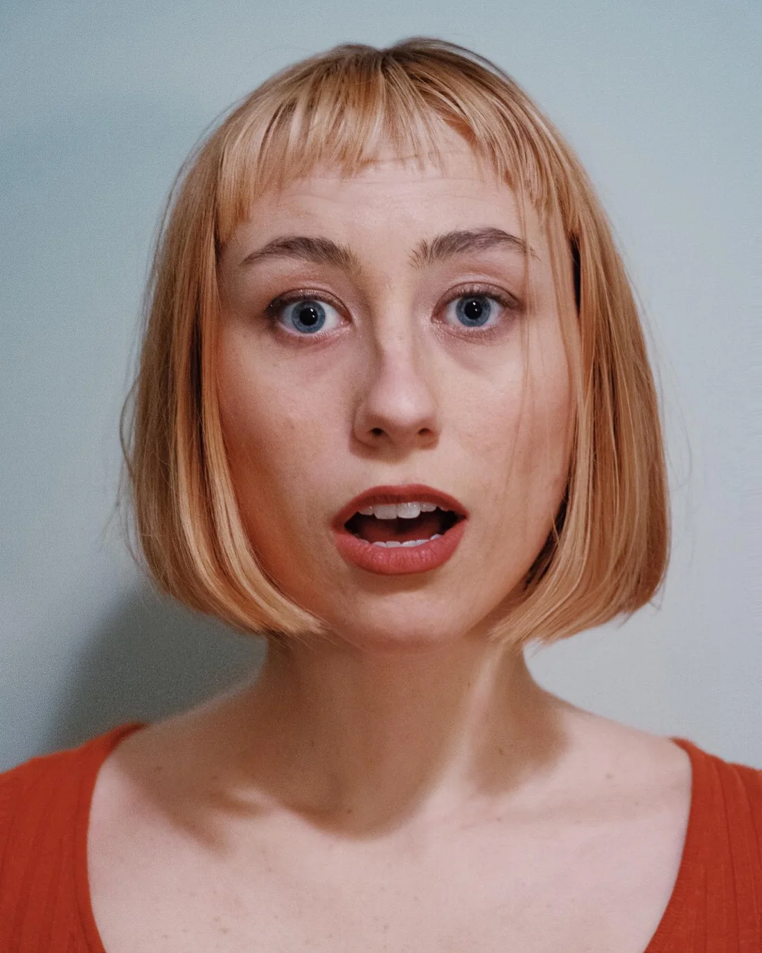 Red cropped bob with short micro bangs and textured ends.