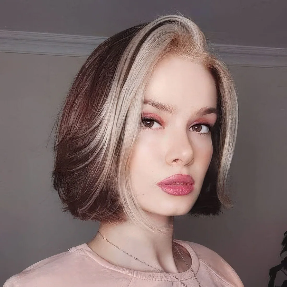 Dark brunette chin-length bob with a platinum blonde money piece that contrasts the hair color.