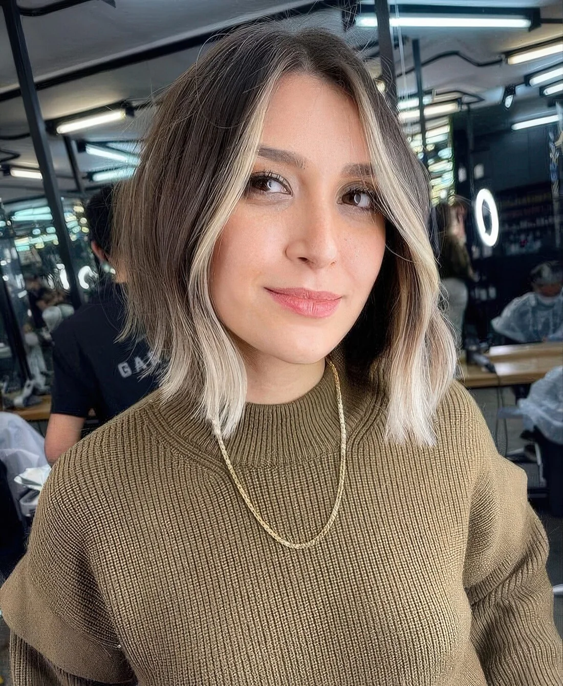 Light brunette long bob with a blonde money piece and waves.