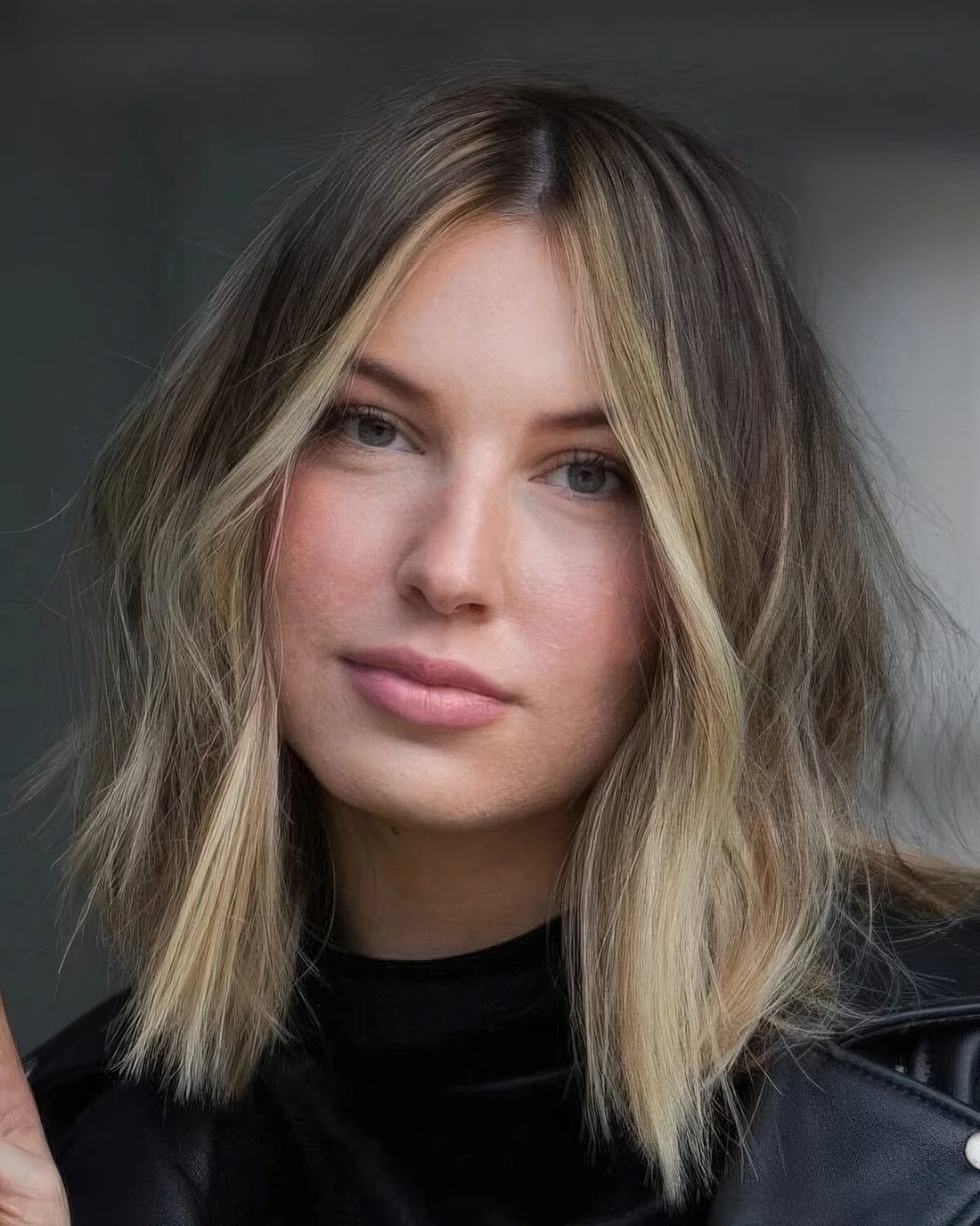 Long and messy brunette bob with a blonde money piece and an ombre touch.