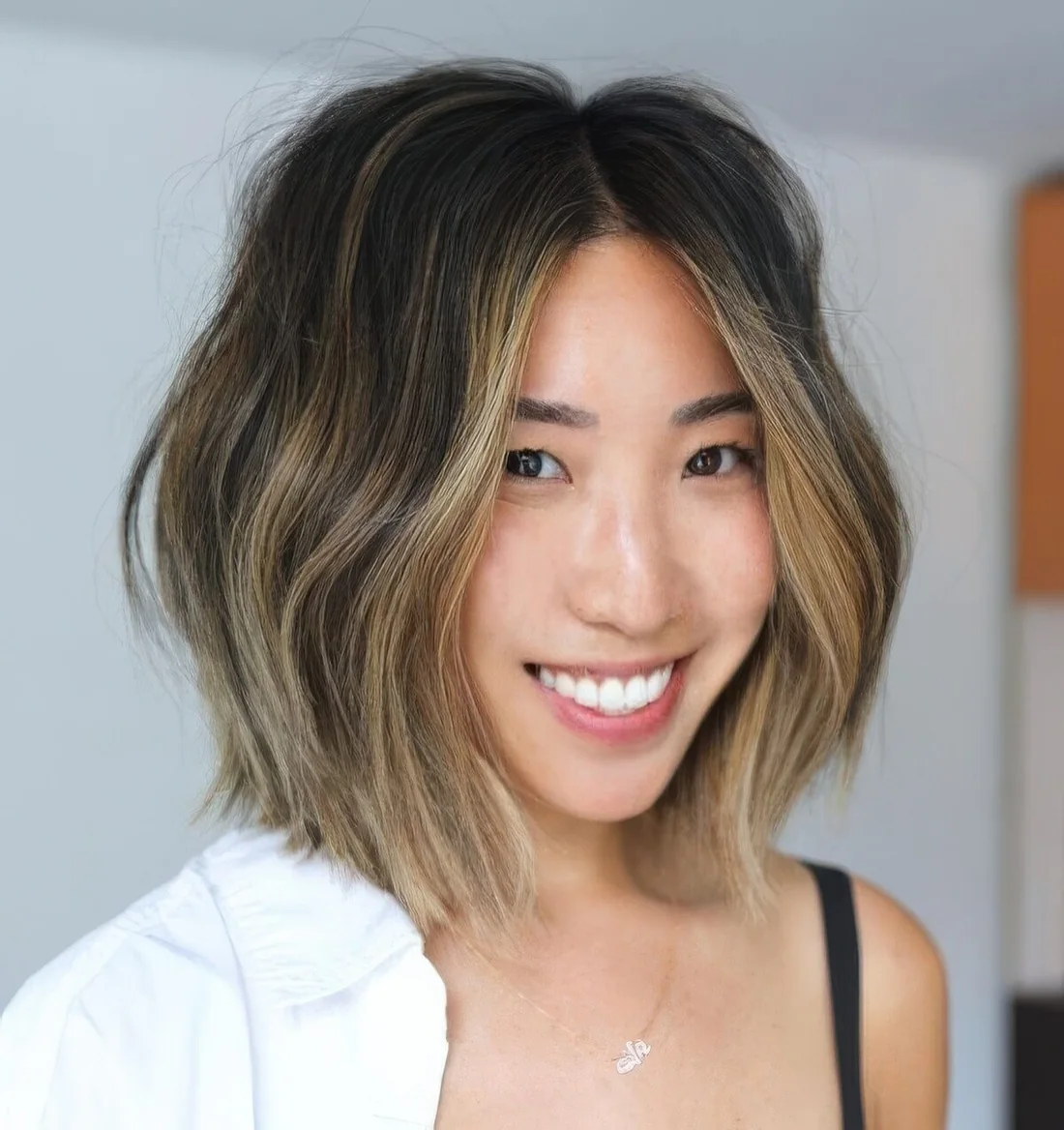 Brunette long bob with blonde balayage and a money piece plus waves.