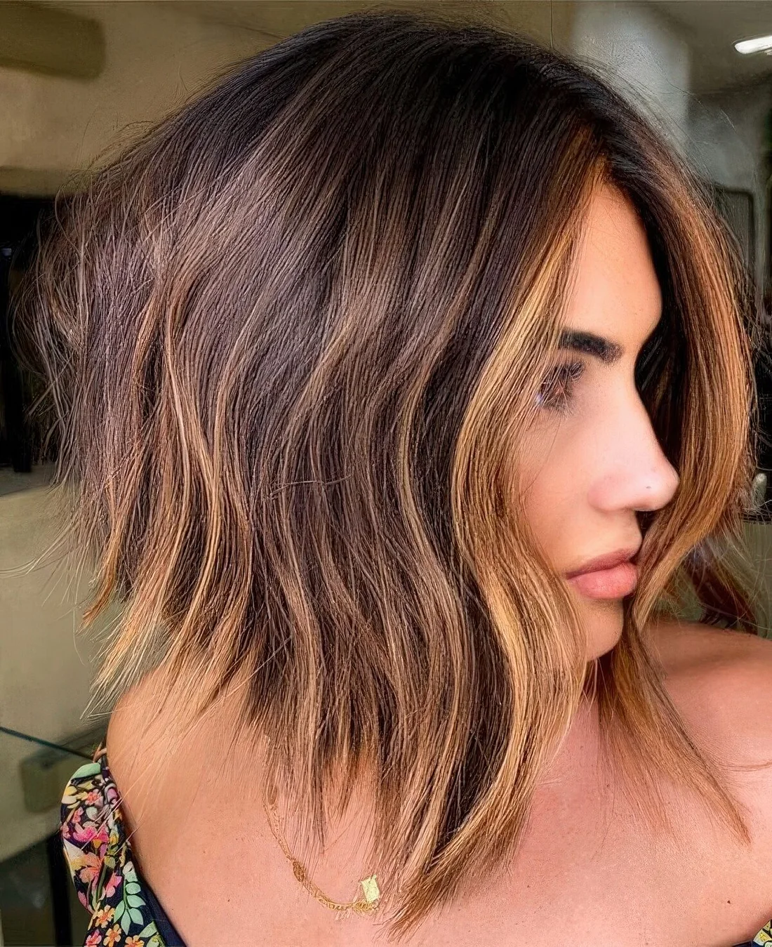 Line dark brunette bob with caramel balayage and a money piece plus messy waves.