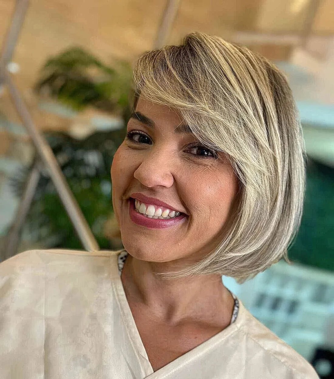 Photo showing blonde bob with a sweeping fringe, with the hairstyle clearly visible.