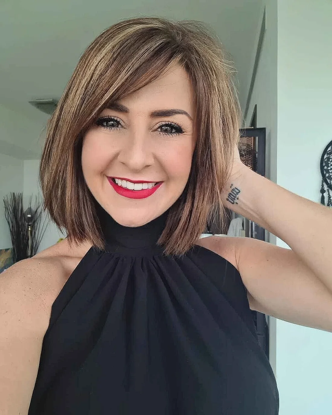 Medium bob with blonde balayage and side bangs.