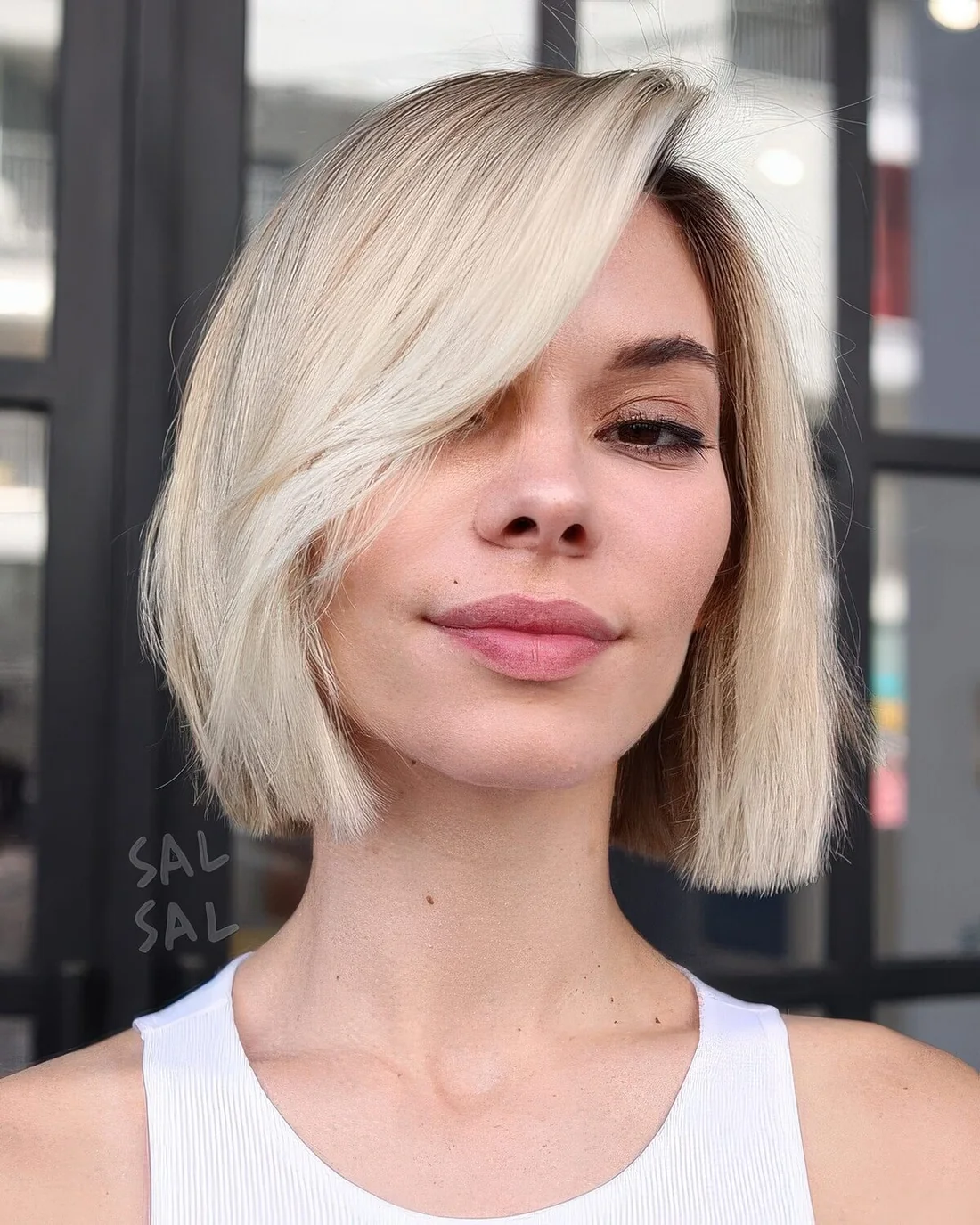 Photo showing blonde midi bob with side bangs, with the hairstyle clearly visible.