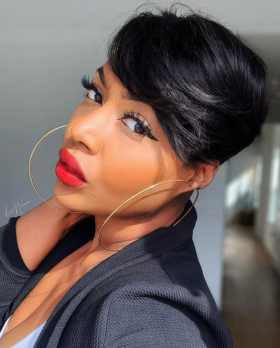 Long black pixie with side bangs and a lot of volume.