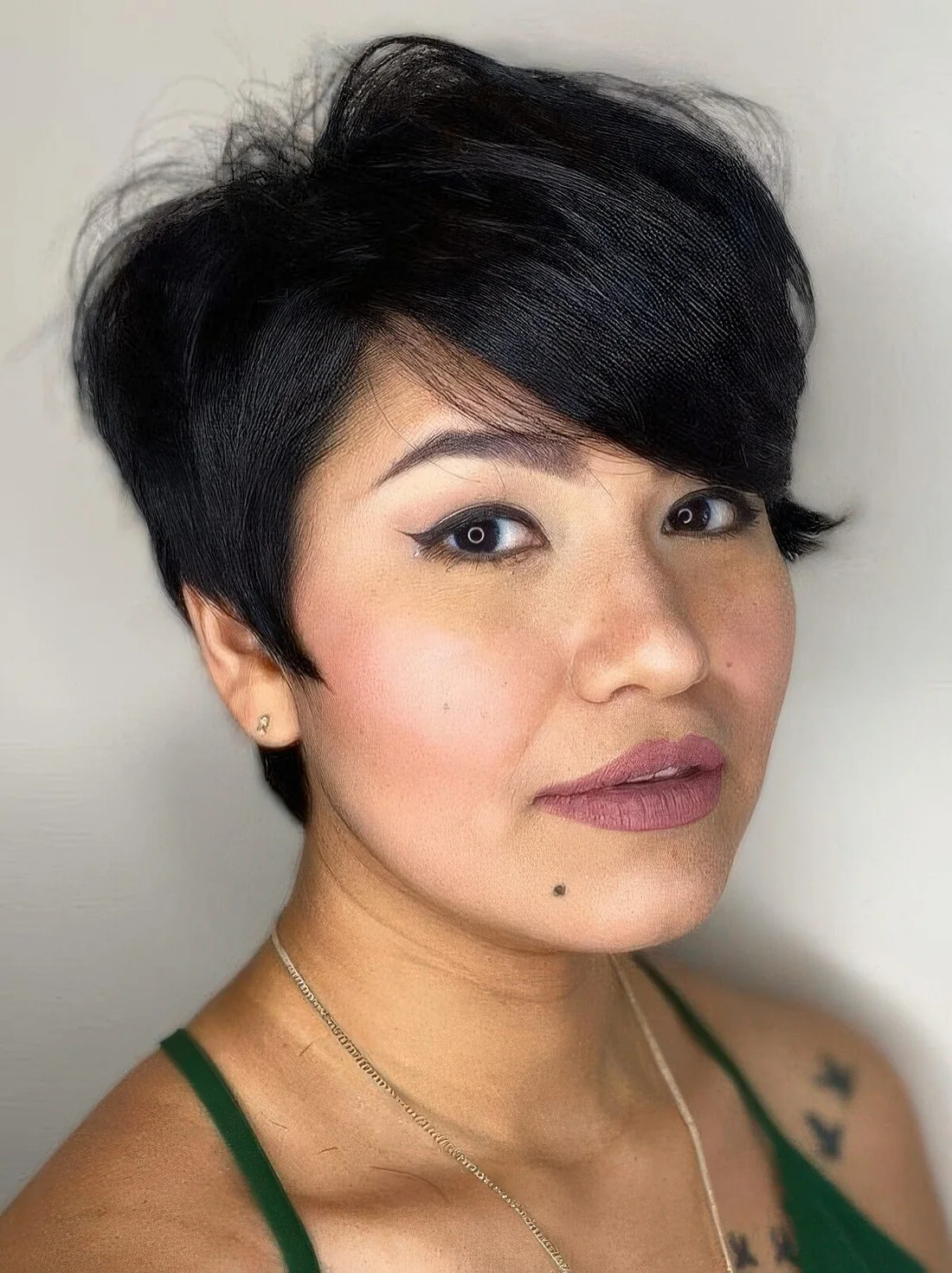 Long pixie haircut with a side fringe and a lot of volume.
