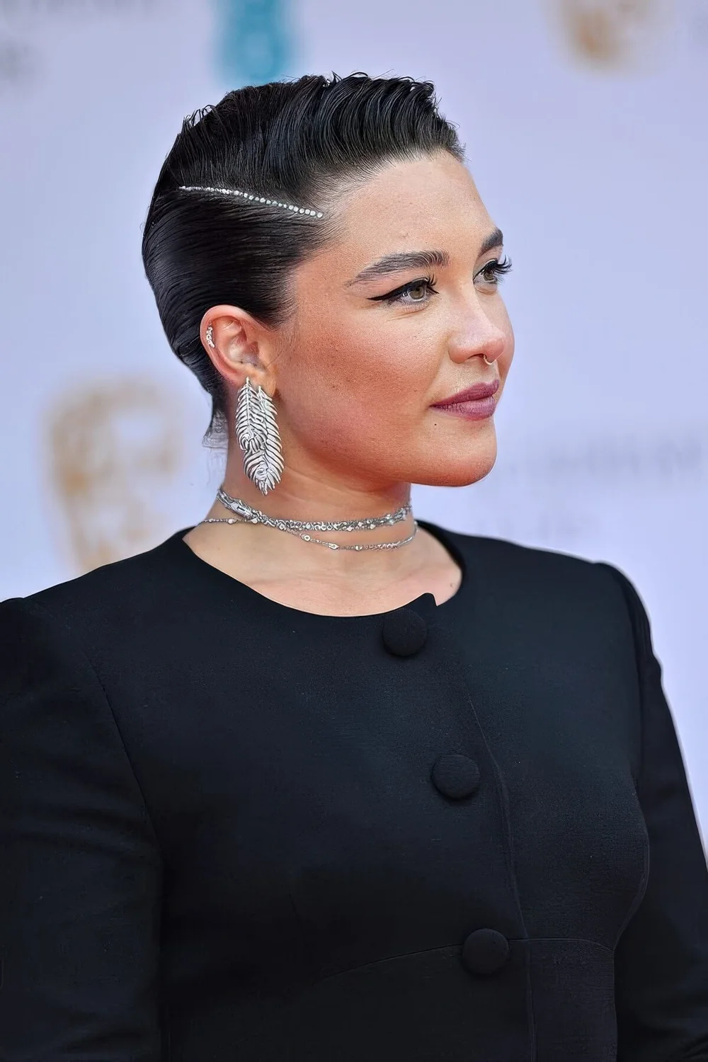 Black pixie haircut styled up, with slick hair and parting highlighted with rhinestones for a special occasion.