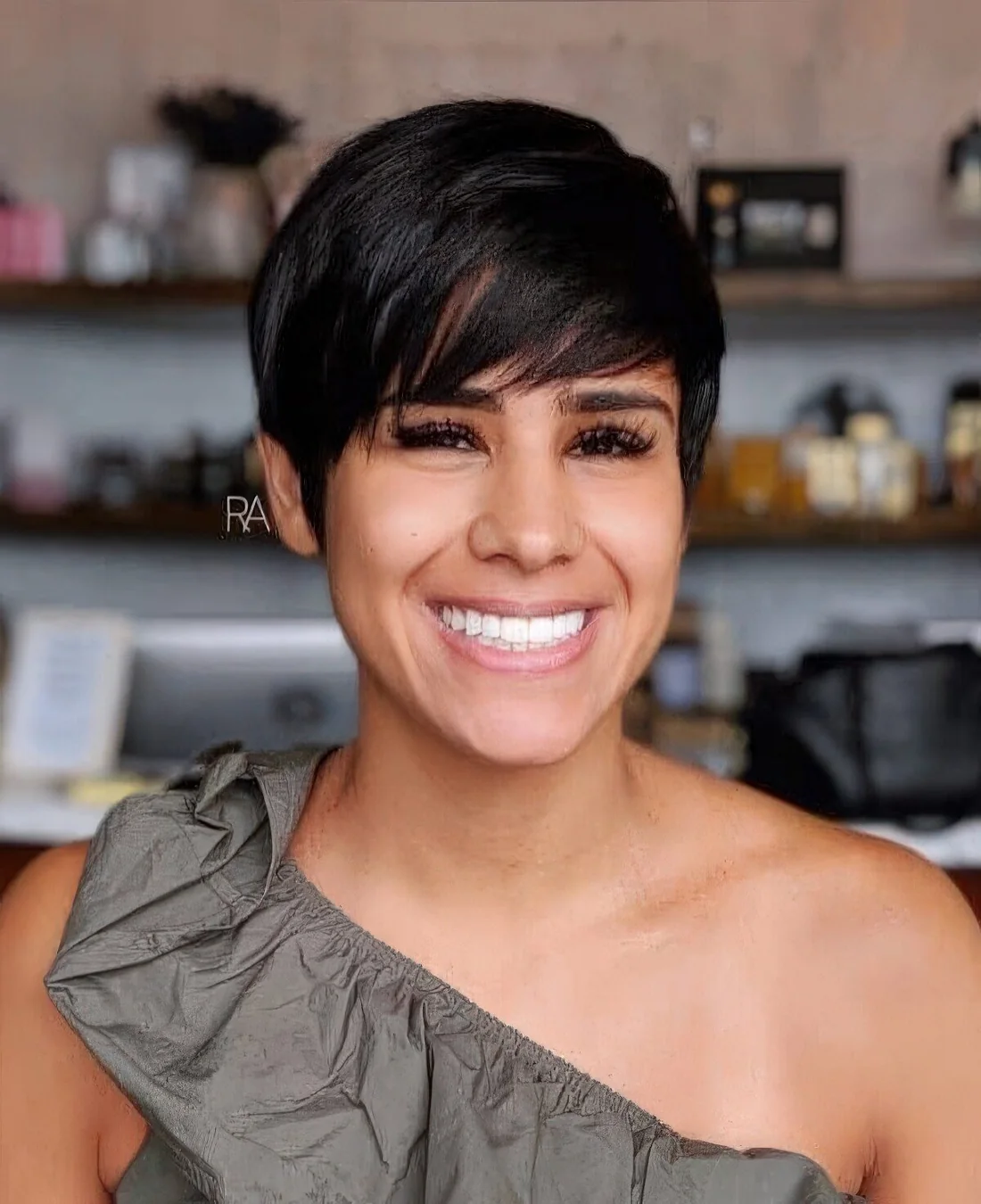 Black pixie haircut with long side swept bangs.