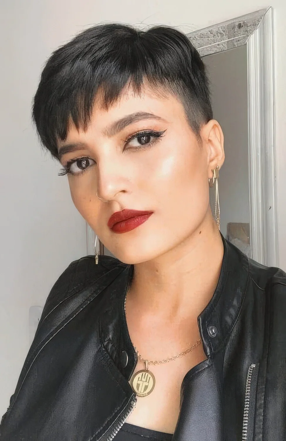 Black pixie haircut with wispy bangs and volume.