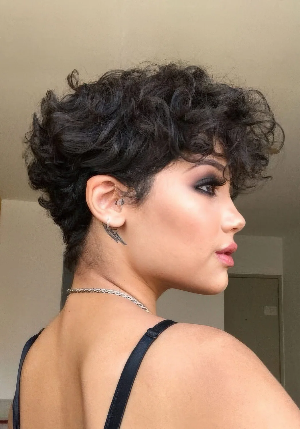 Black wavy pixie with a lot of volume and longer bangs.