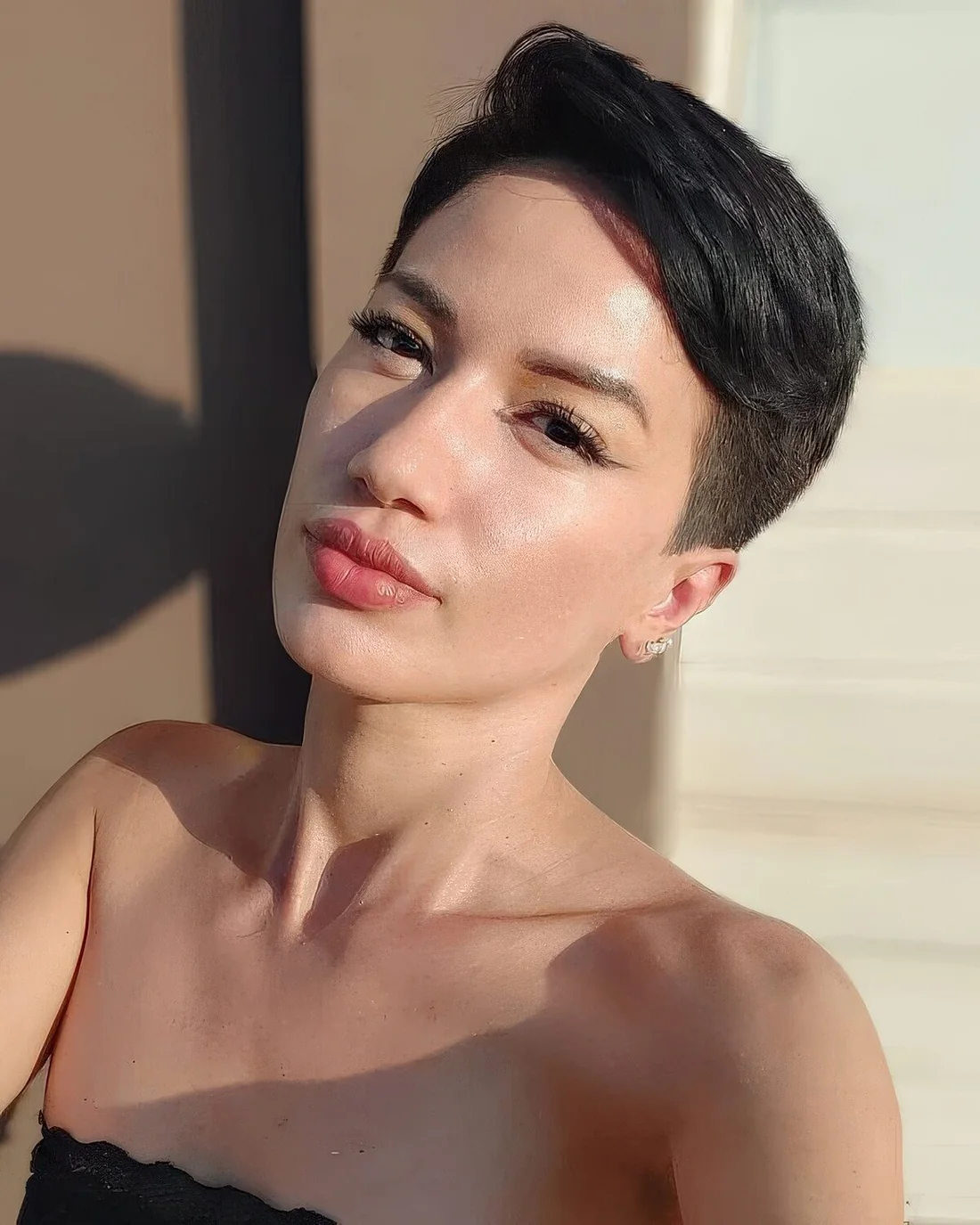 Classyc black pixie haircut with short sides and long top plus some volume.