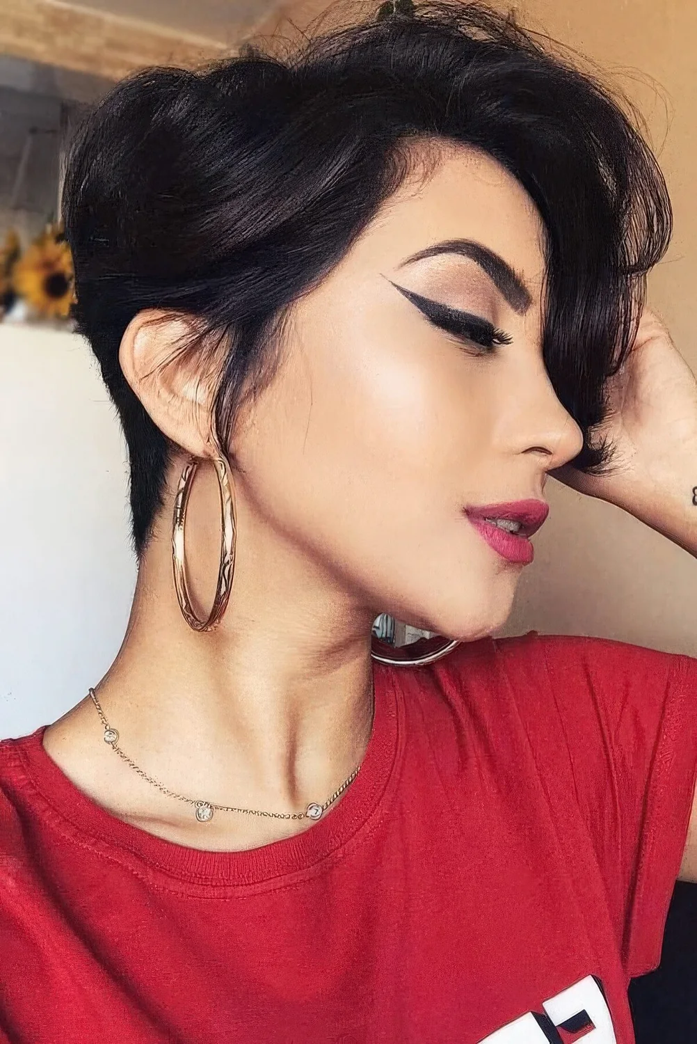 Long and voluminous black pixie with side bangs and a bit of waves.