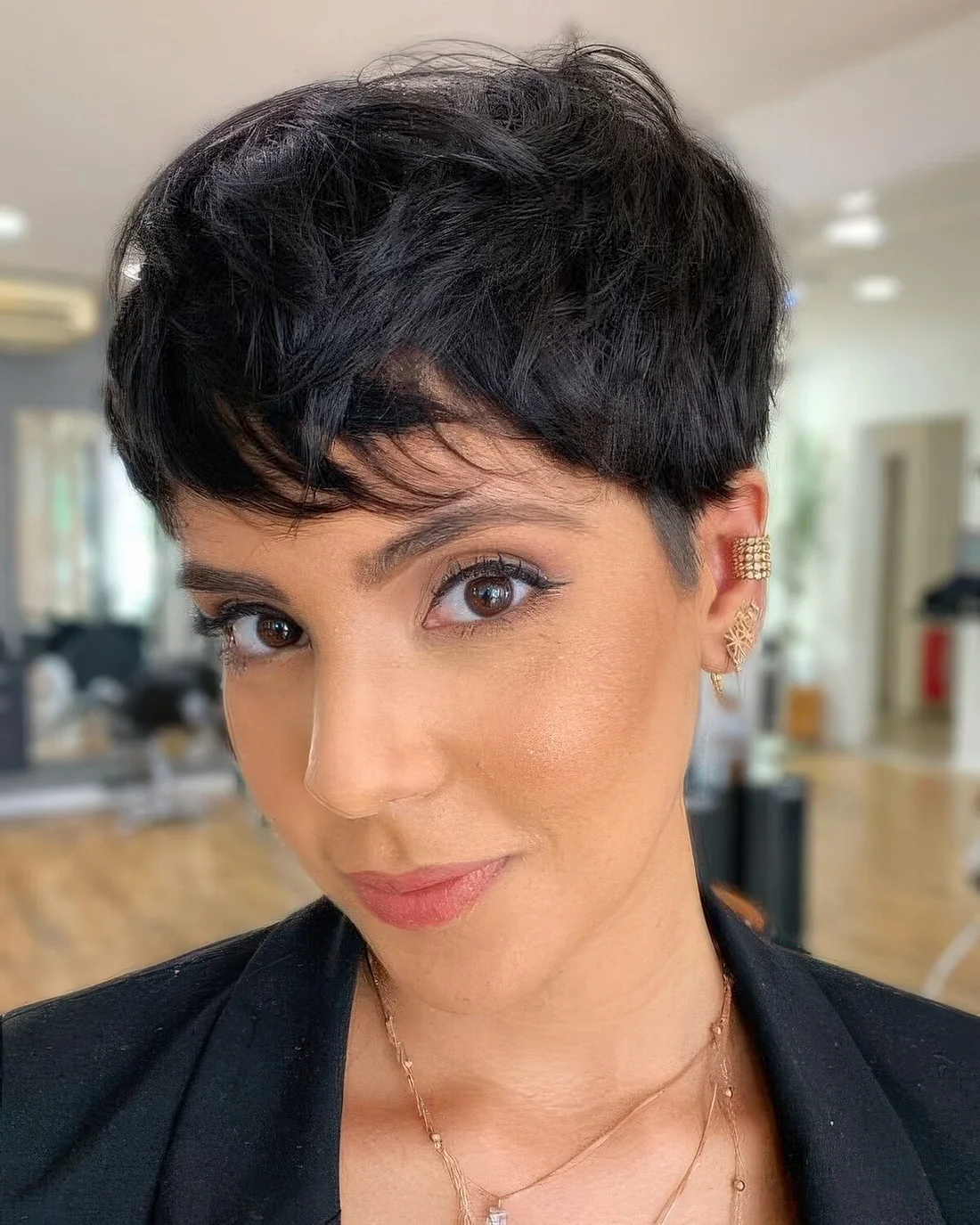 Long shaggy messy textural black pixie haircut with a lot of volume.