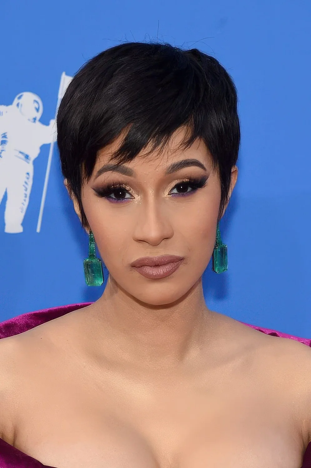 Black pixie haircut with messy bangs and volume on straight hair.