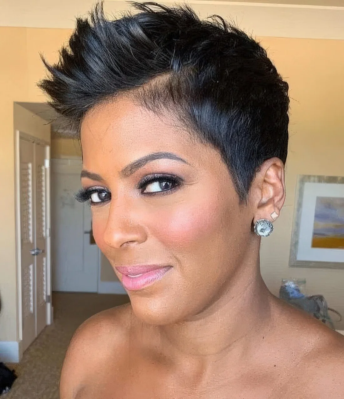 Sassy black pixie haircut styled up, with a lot of volume.