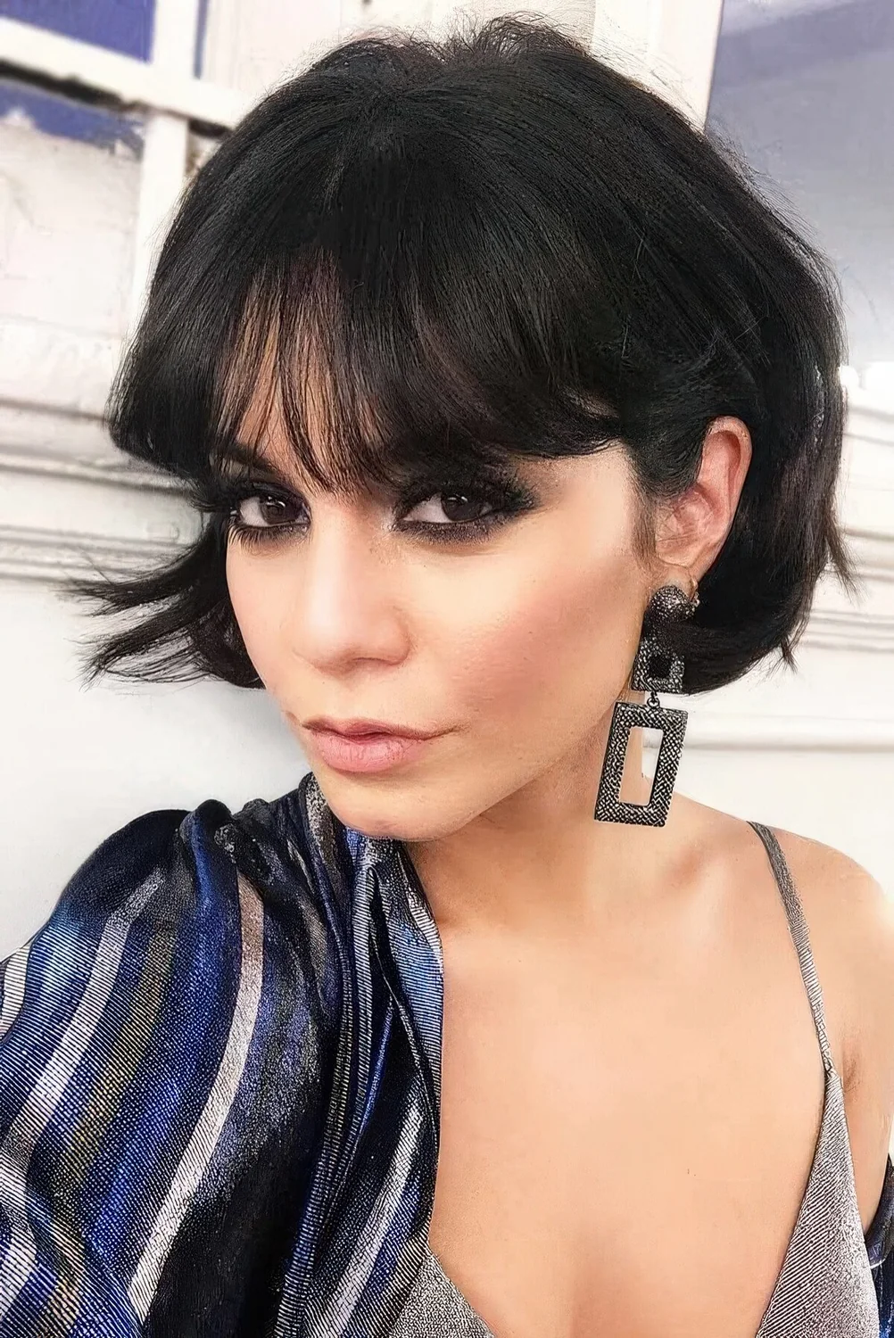 Black chin-length bob with outgrown bangs and much volume.