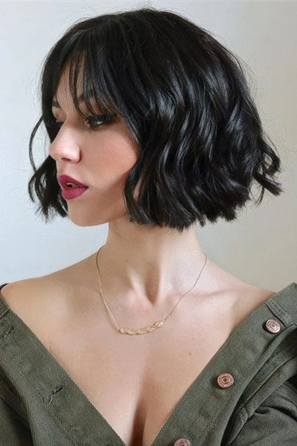 Black wavy chin-length bob with wispy bangs.