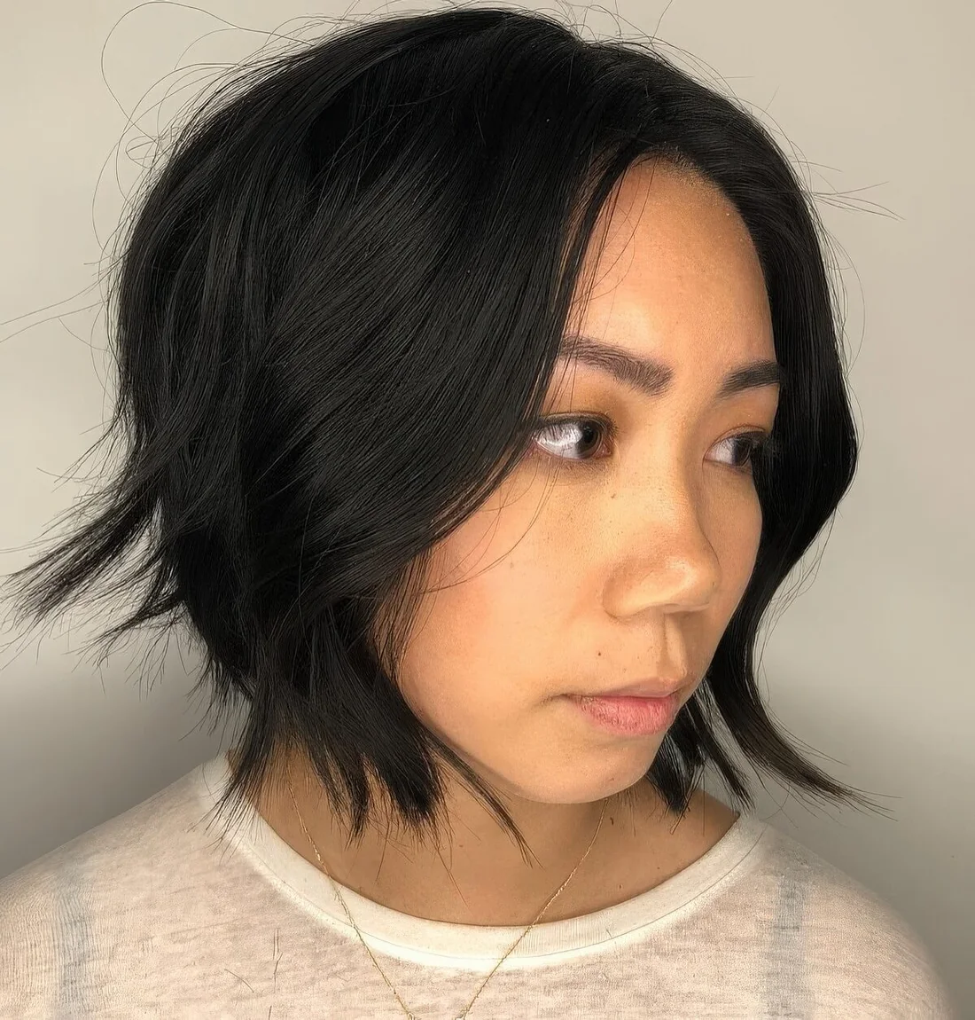 Chopped chin-length bob with long bangs and messy waves.