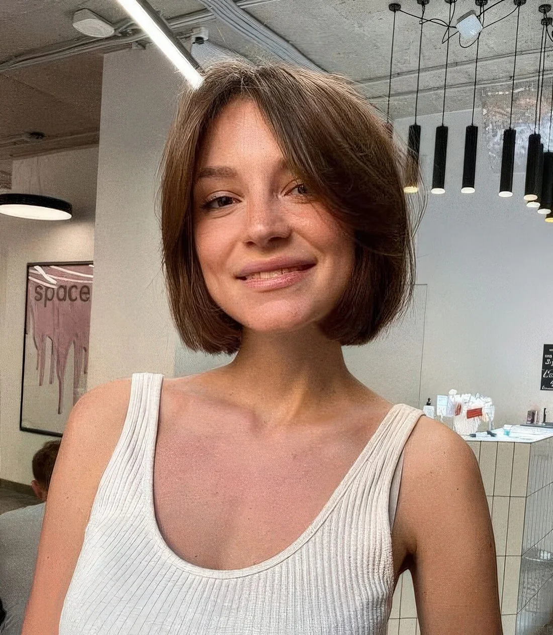 Brown Chin-Length Bob with Curtain Bangs.