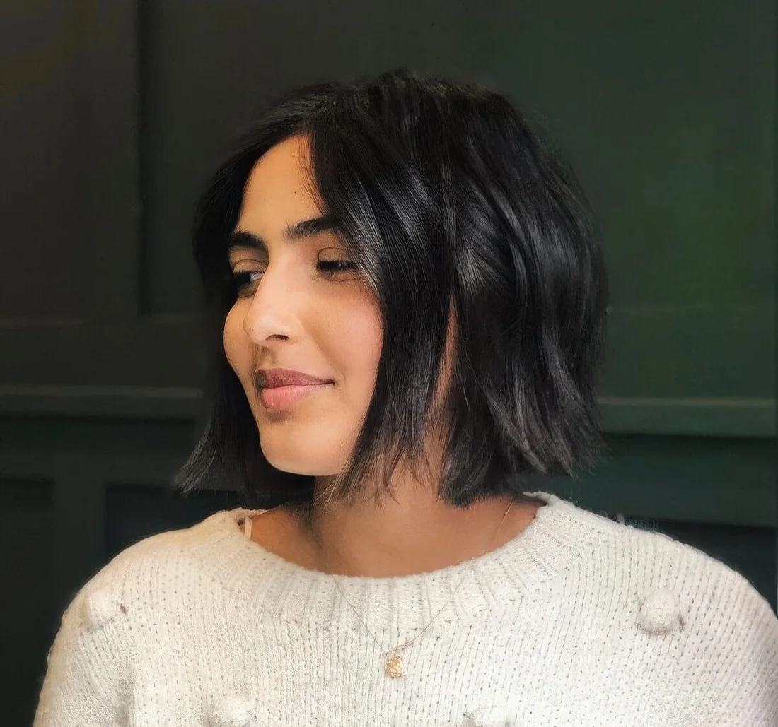 Dark brown, almost black chin-length bob with a bit of highlights and waves.