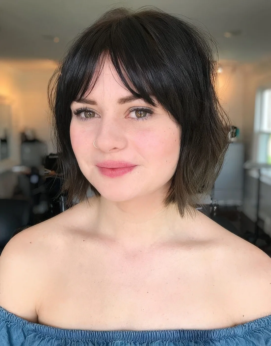 Messy and textural brown bob with layered and bottleneck bangs.