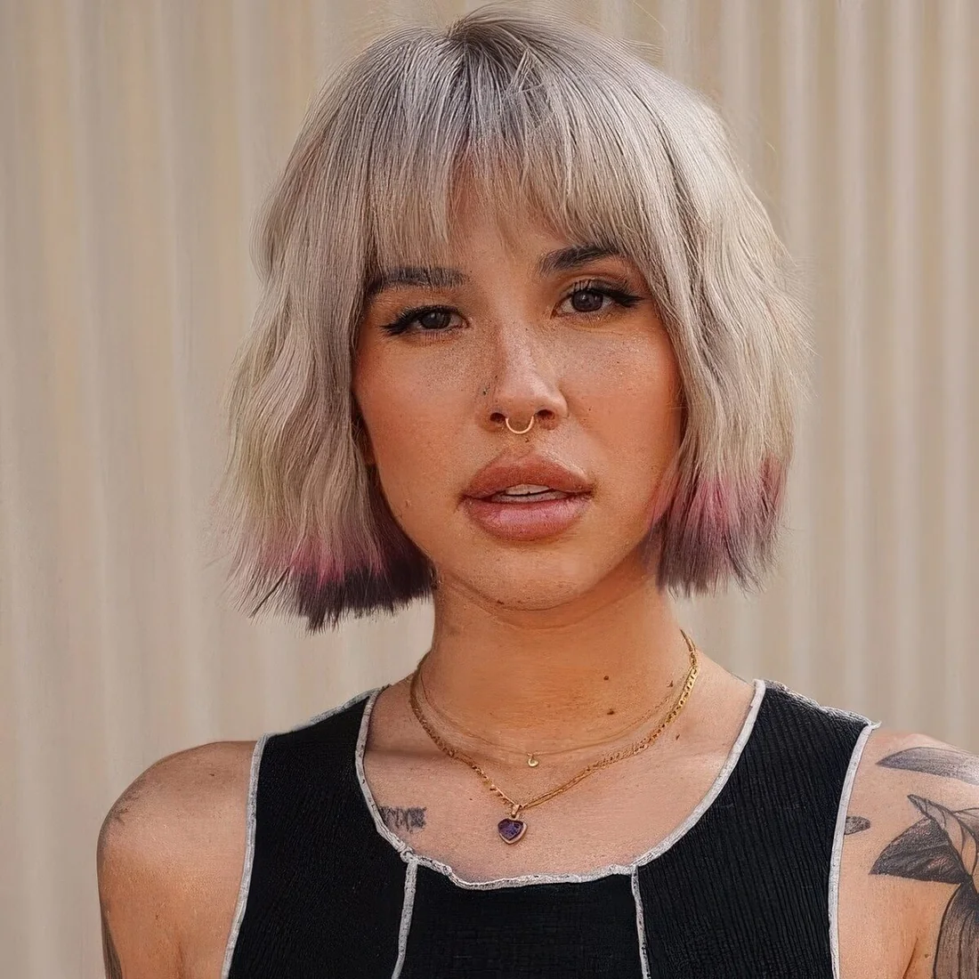 Textural blonde chin-length bob with bangs, pink and purple ends.