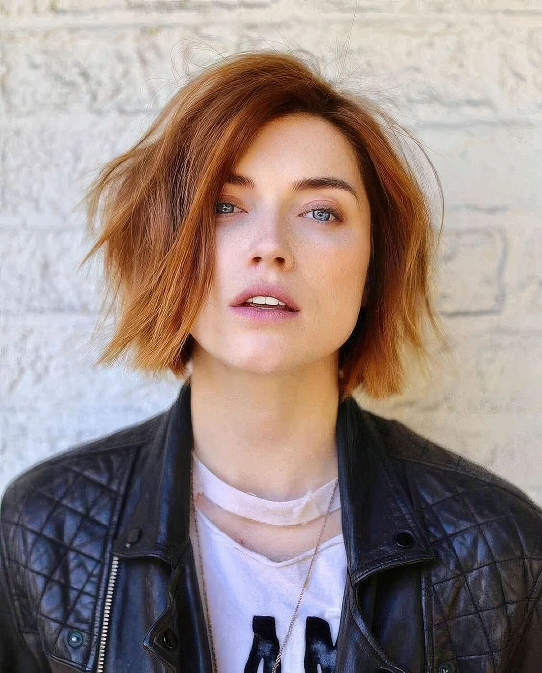 Textural and messy ginger chin-length bob with a darker root and side part.