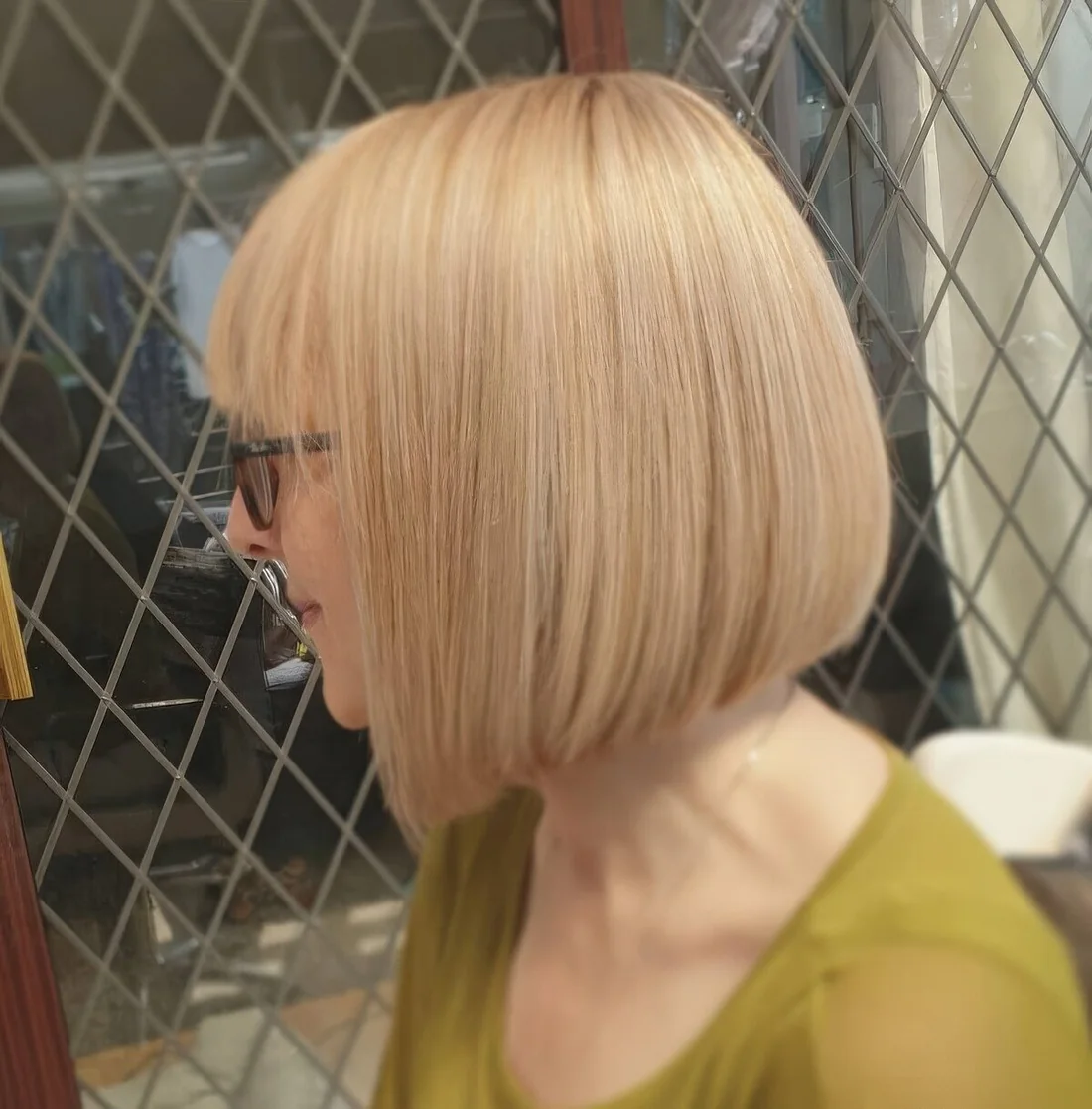 Photo showing blonde A line chin bob with bangs, with the hairstyle clearly visible.