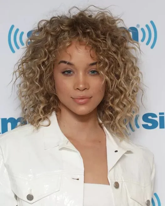 Wispy blonde ringlets and lifted roots give Jasmine Sanders a cool, choppy appearance, add some grit to your curls with a texturing spray.