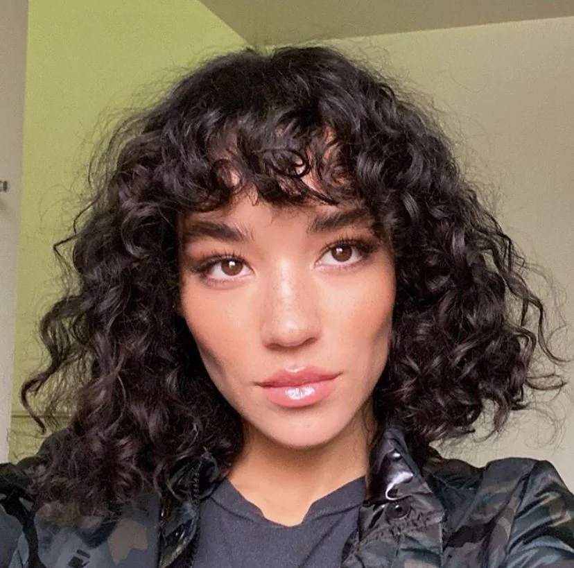 Photo showing black curly bob, with the hairstyle clearly visible.