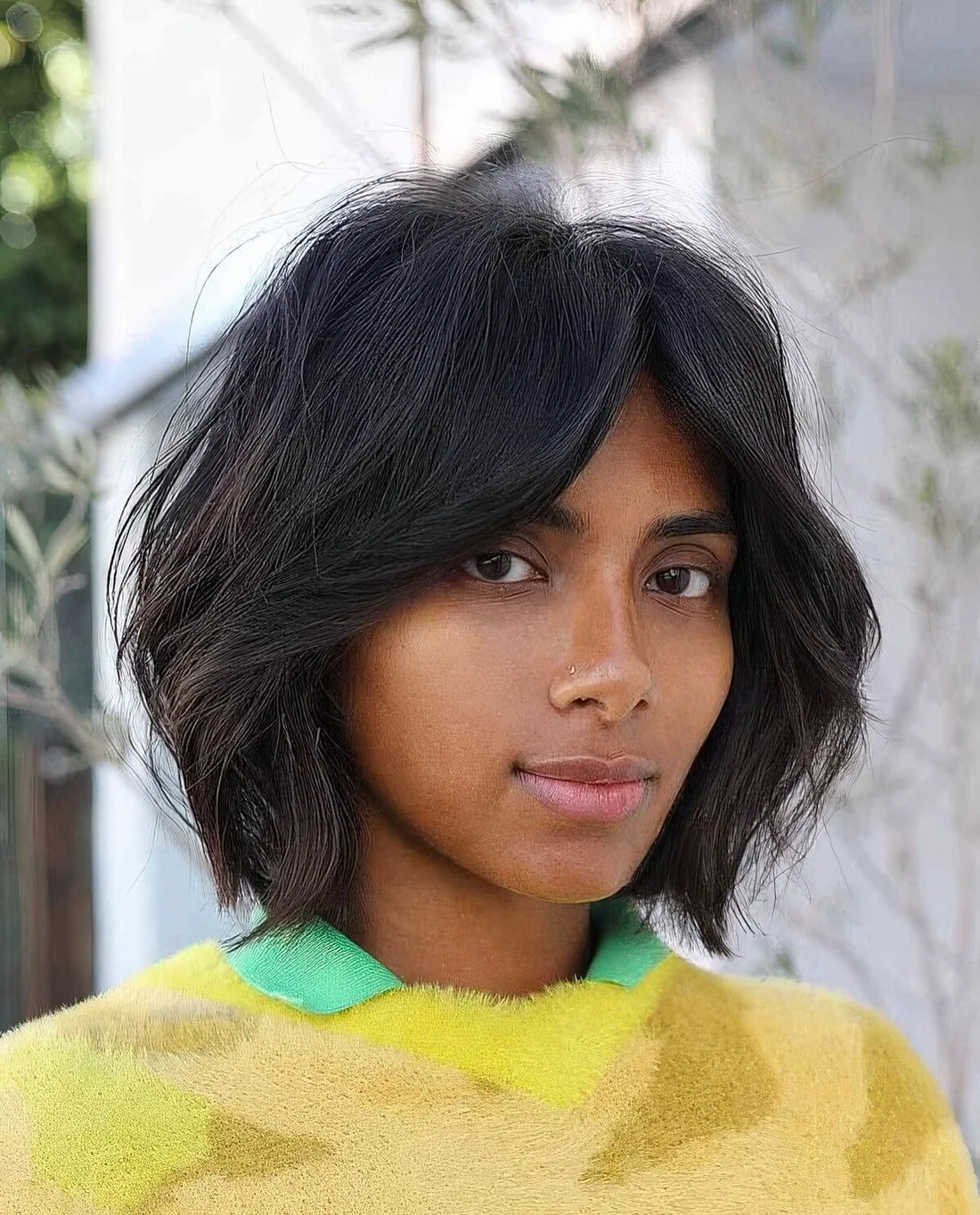 Black dimensional bob with bottleneck bangs and textured hair.