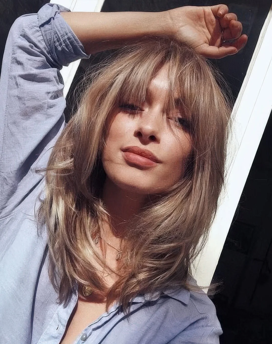 Bronde light bronde butterfly haircut with bottleneck bangs.