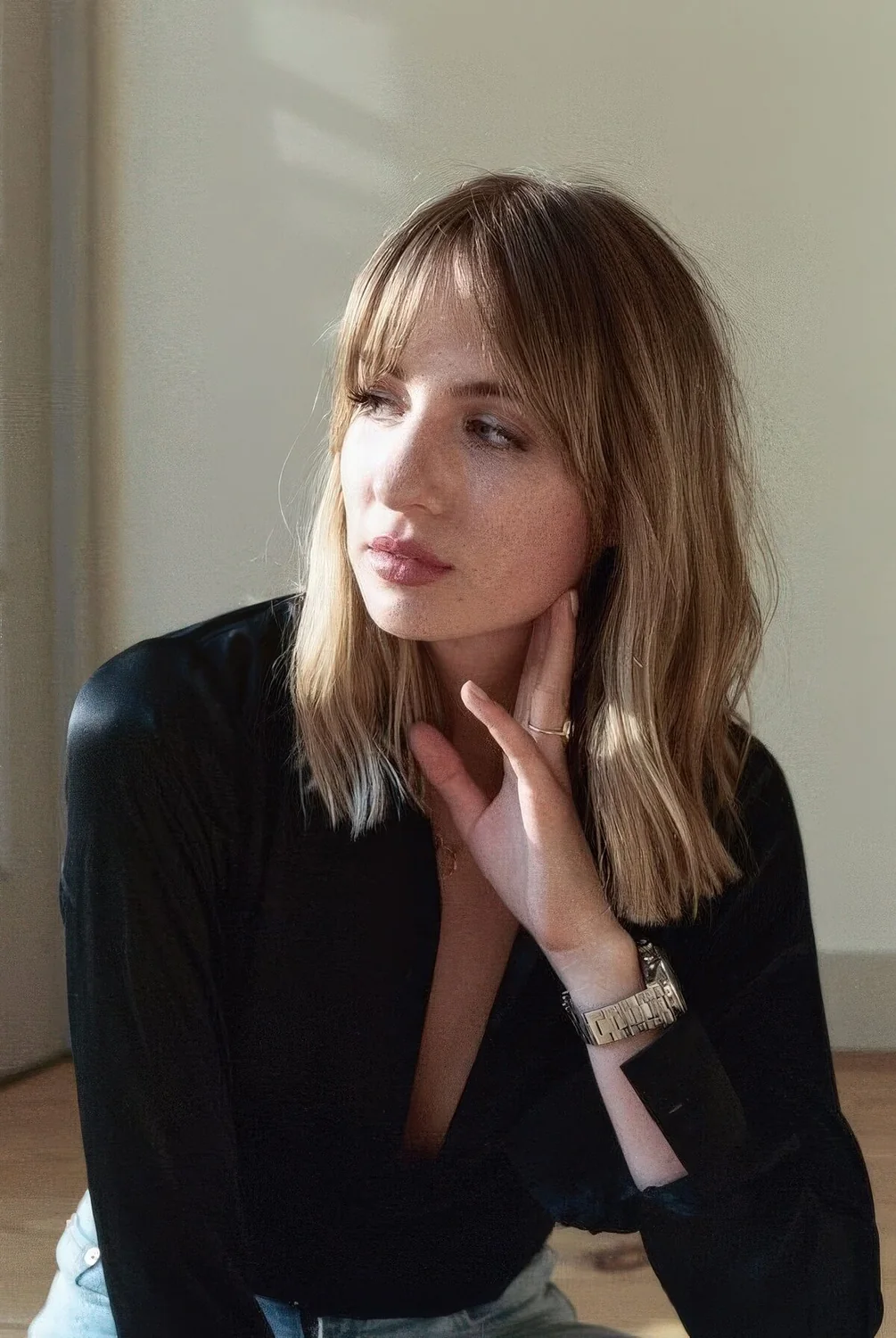 Medium-length blonde haircut with bottleneck bangs.