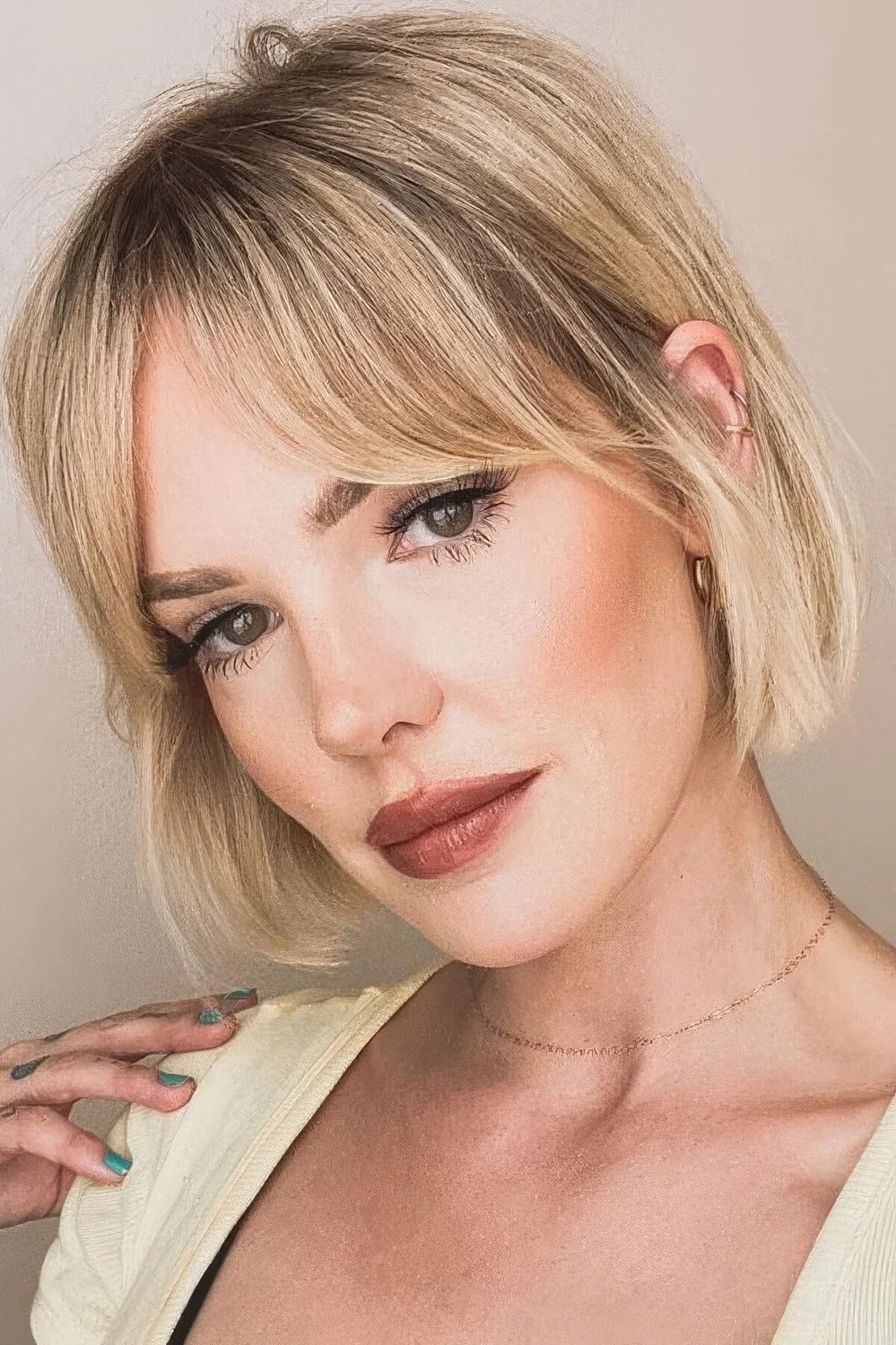 Blonde jaw-length bob with bottleneck bangs.