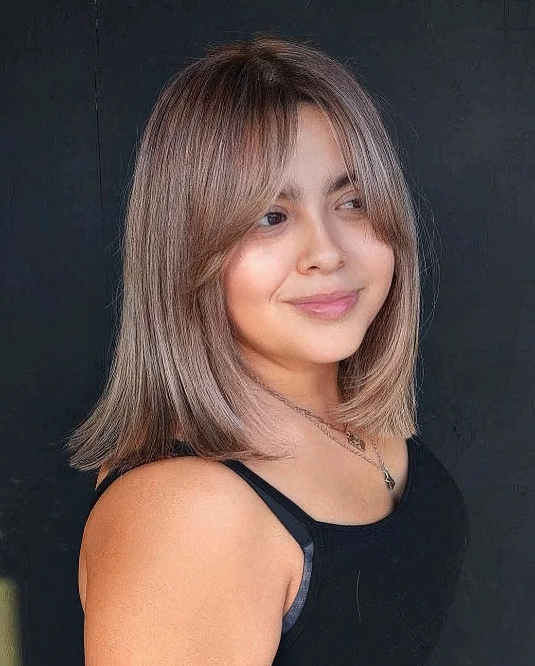 Light brunette shoulder-length hair with bottleneck bangs and a sleek texture.