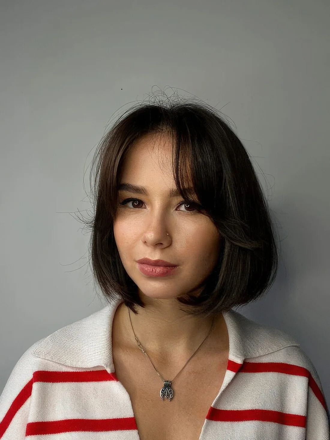 Dark brown box hairstyle with curtain bangs that give it a softer look and curled ends for the same.
