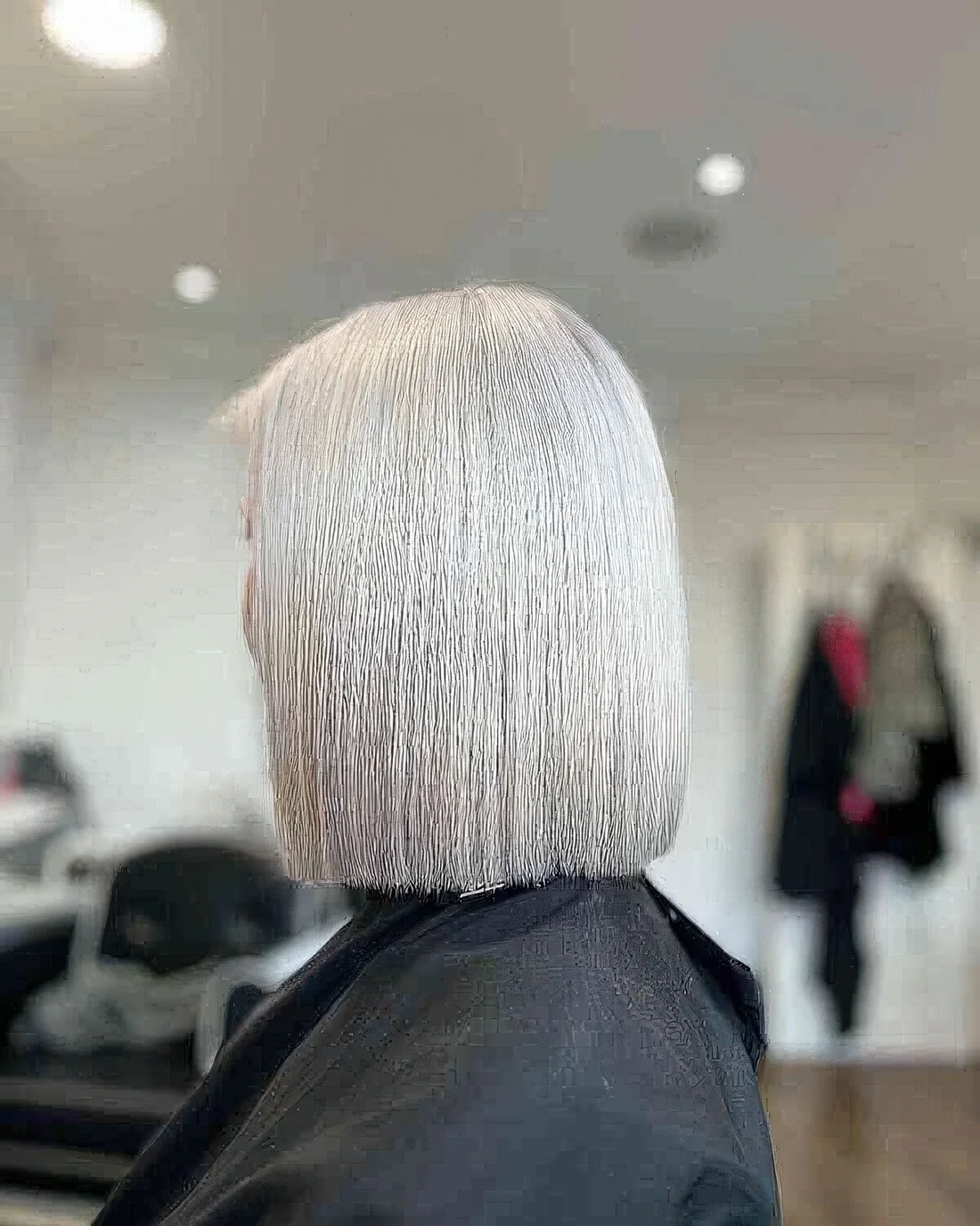 Photo showing icy blonde long bob, with the hairstyle clearly visible.