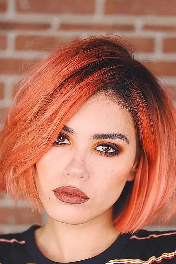 Take on the boy bob haircut fiery red hair with a black root and much volume for those who dare.