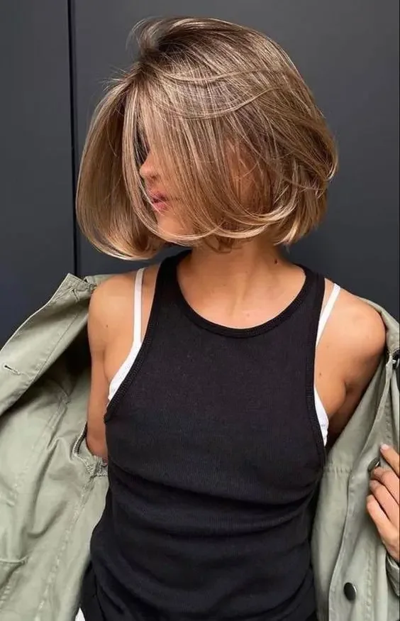 Boy bob haircut on naturally sunkissed brunette hair, with much volume.