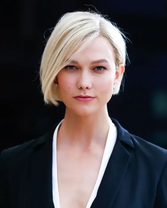 Creamy blonde sleek boy bob with side part and some volume already.