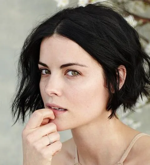 Jamie Alexander wearing a black wavy boy bob with center parting and much volume.